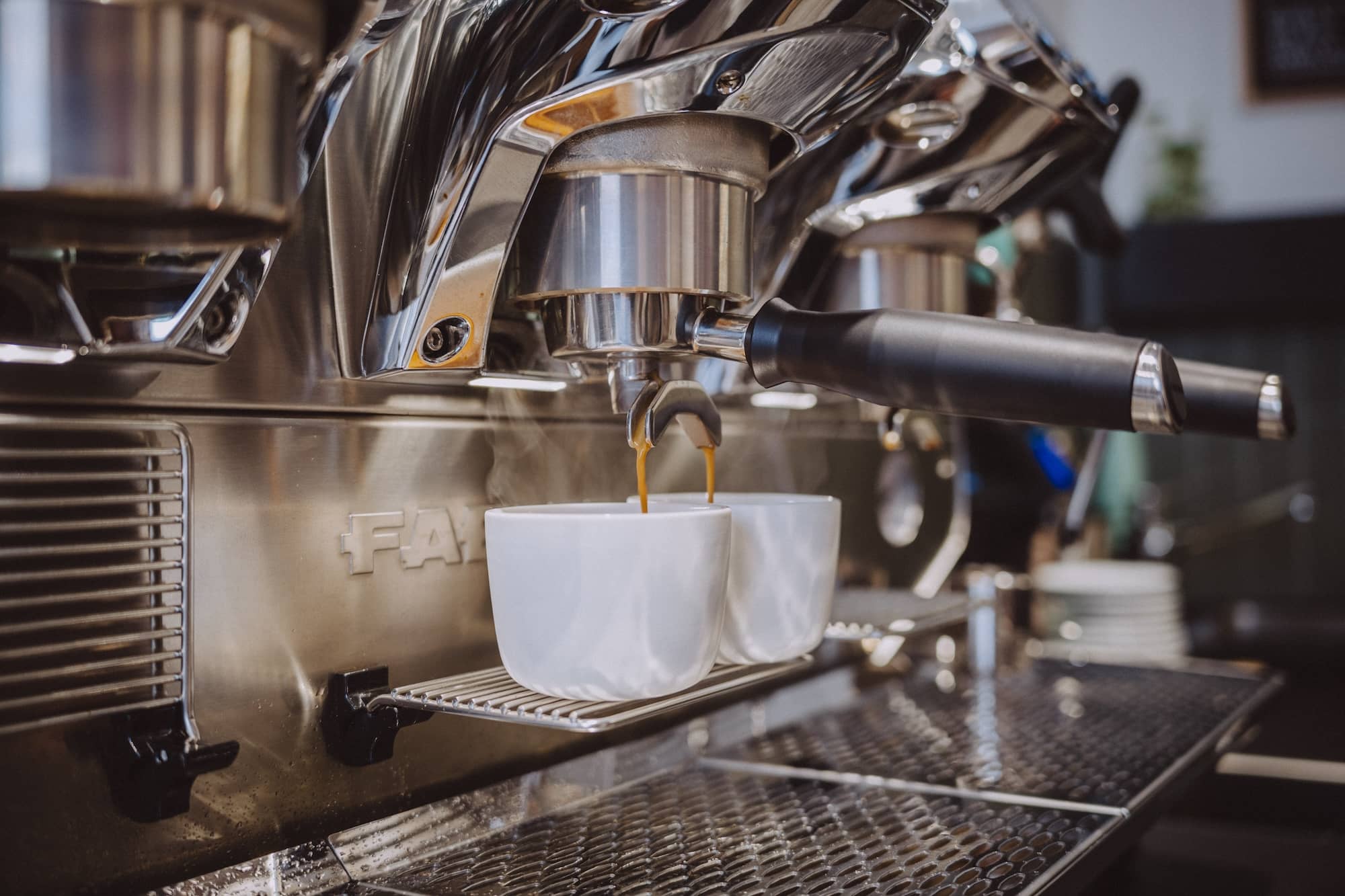Frisch gebrühter Kaffee läuft aus einer Siebträgermaschine im Kaffeesack-Laden – ein Moment voller Genuss und Handwerkskunst.